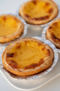 Portekiz 'in geleneksel tatlı tatlısı Pastel de nata yumurtalı kremalı tart pastası. Beyaz arka planda yakın plan.