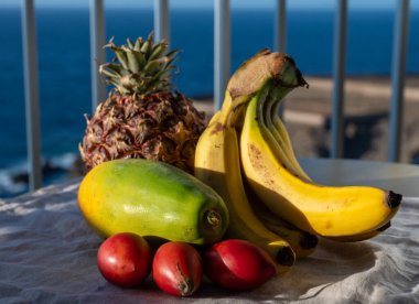 İspanya 'da çevre tarımı, Tenerife adası ve mavi deniz manzaralı tropikal organik sarı Kanarya muzları, ananas, papaya ve tamarillo meyveleri, Kanarya adaları