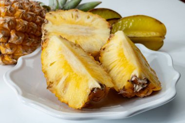 İki taze olgun Fransız ananası ya da Mauritius 'tan tatlı bebek ananas ve yıldızmeyvesi egzotik meyveler.