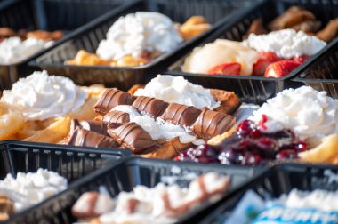 Farklı malzemelerle zenginleştirilmiş taze waffle çeşitleri, tatlı tatlılar, çikolata, krema, meyve ve meyveler, pastanede şekerleme dükkanı, eski Volendam, geleneksel Hollanda tatlıları