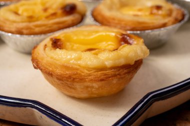 Portekiz 'in geleneksel tatlı tatlısı Pastel de nata yumurtalı kremalı tart pastası. Tahtaya yakın.