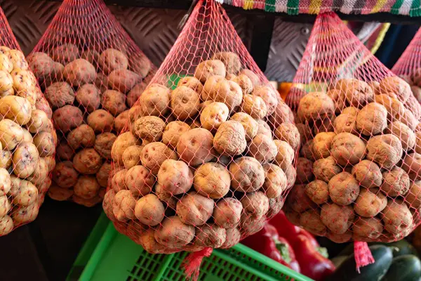 Küçük tatlı patates papalar markette, ana yemek kanarya adalarında, çok tuzlu pişirilmiş ve mojo sosuyla servis edilmiş, ağlarda asılı.