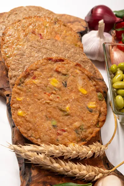 Pişmemiş vejetaryen köfteler veya hamburgerler tahıl, soya fasulyesi, sebze ve baklagillerden yapılır.