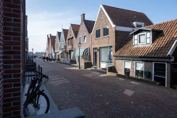 Kuzey Hollanda 'da turistler, Amsterdam yakınlarındaki eski otantik balıkçı köyü Volendam' da eski evler ve ilkbaharda dar sokaklar