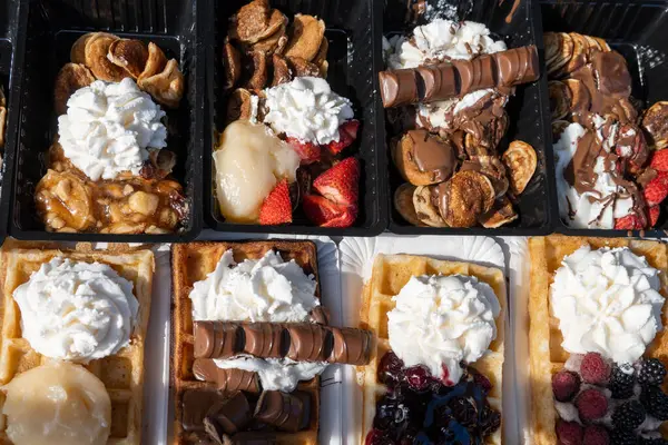 Farklı malzemelerle zenginleştirilmiş taze waffle çeşitleri, tatlı tatlılar, çikolata, krema, meyve ve meyveler, pastanede şekerleme dükkanı, eski Volendam, geleneksel Hollanda tatlıları