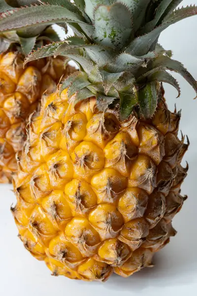 İki taze olgun Fransız ananası ya da Mauritius 'tan gelen tatlı bebek ananasları. Beyaz arka planda.