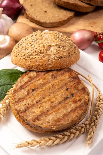 Vejetaryen veya vejetaryen köftelerden hamburgerler yapmak veya tahıldan yapılmış hamburgerler, hayati buğday glüten yemekleri, ızgara sağlıklı yiyecekler.