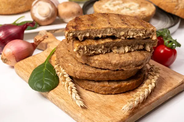 Tahıldan yapılmış yuvarlak vejetaryen köfteler ya da hamburgerler, hayati buğday glüten yiyecekler, pişirilmemiş ve ahşap kalaslarda kızartılmış.