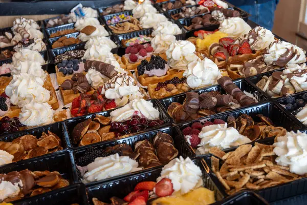 Farklı malzemelerle zenginleştirilmiş taze waffle çeşitleri, tatlı tatlılar, çikolata, krema, meyve ve meyveler, pastanede şekerleme dükkanı, eski Volendam, geleneksel Hollanda tatlıları