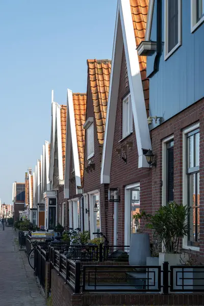 Kuzey Hollanda 'da turistler, Amsterdam yakınlarındaki eski otantik balıkçı köyü Volendam' da eski evler ve ilkbaharda dar sokaklar