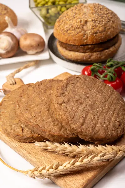 Tahıldan yapılmış yuvarlak vejetaryen köfteler ya da hamburgerler, hayati buğday glüten yiyecekler, pişirilmemiş ve ahşap kalaslarda kızartılmış.