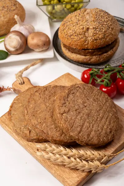 Tahıldan yapılmış yuvarlak vejetaryen köfteler ya da hamburgerler, hayati buğday glüten yiyecekler, pişirilmemiş ve ahşap kalaslarda kızartılmış.