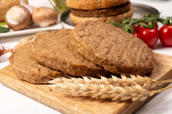 Tahıldan yapılmış yuvarlak vejetaryen köfteler ya da hamburgerler, hayati buğday glüten yiyecekler, pişirilmemiş ve ahşap kalaslarda kızartılmış.
