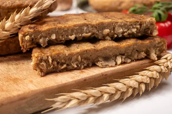 Tahıldan yapılmış yuvarlak vejetaryen köfteler ya da hamburgerler, hayati buğday glüten yiyecekler, pişirilmemiş ve ahşap kalaslarda kızartılmış.