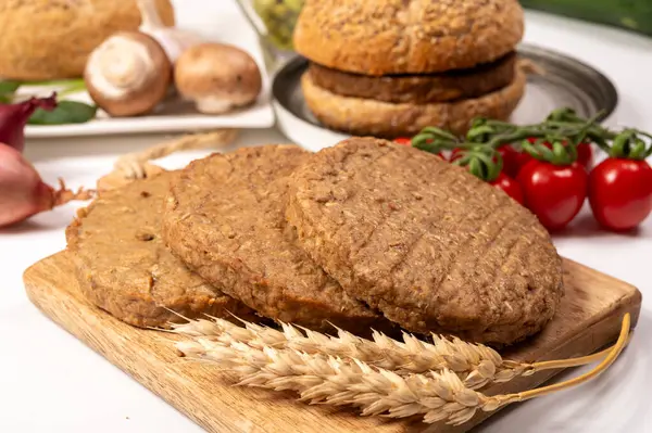 Tahıldan yapılmış yuvarlak vejetaryen köfteler ya da hamburgerler, hayati buğday glüten yiyecekler, pişirilmemiş ve ahşap kalaslarda kızartılmış.
