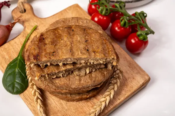 Tahıldan yapılmış yuvarlak vejetaryen köfteler ya da hamburgerler, hayati buğday glüten yiyecekler, pişirilmemiş ve ahşap kalaslarda kızartılmış.