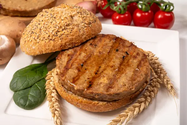 Vejetaryen veya vejetaryen köftelerden hamburgerler yapmak veya tahıldan yapılmış hamburgerler, hayati buğday glüten yemekleri, ızgara sağlıklı yiyecekler.