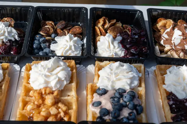 Farklı malzemelerle zenginleştirilmiş taze waffle çeşitleri, tatlı tatlılar, çikolata, krema, meyve ve meyveler, pastanede şekerleme dükkanı, eski Volendam, geleneksel Hollanda tatlıları