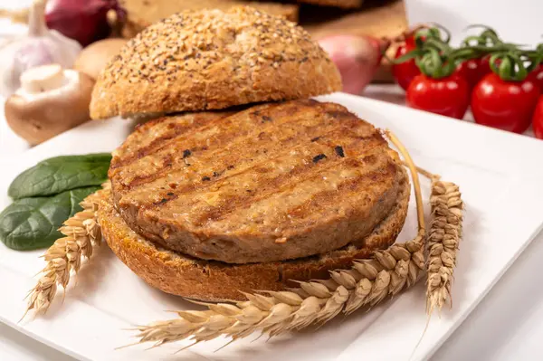 Vejetaryen veya vejetaryen köftelerden hamburgerler yapmak veya tahıldan yapılmış hamburgerler, hayati buğday glüten yemekleri, ızgara sağlıklı yiyecekler.