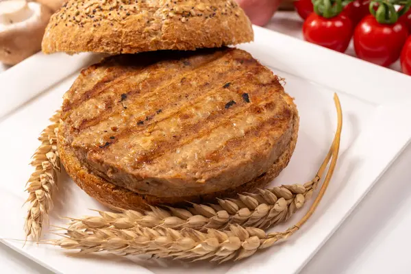 Vejetaryen veya vejetaryen köftelerden hamburgerler yapmak veya tahıldan yapılmış hamburgerler, hayati buğday glüten yemekleri, ızgara sağlıklı yiyecekler.