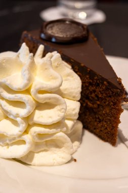 Avusturya kaynaklı kayısı reçelli ünlü Sachertorte çikolatalı keki Viyana 'daki eski klasik kafe restoranında kremayla servis ediliyor.