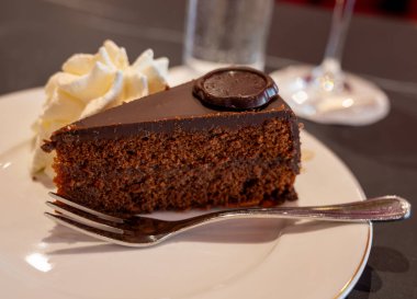 Avusturya kaynaklı kayısı reçelli ünlü Sachertorte çikolatalı keki Viyana 'daki eski klasik kafe restoranında kremayla servis ediliyor.