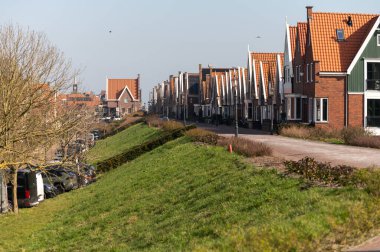 Kuzey Hollanda 'da turistler, Amsterdam yakınlarındaki eski otantik balıkçı köyü Volendam' da eski evler ve ilkbaharda dar sokaklar