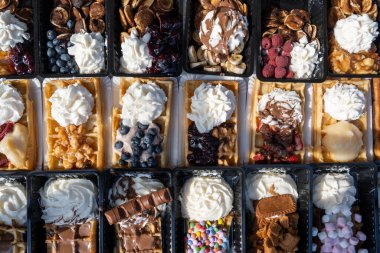 Farklı malzemelerle zenginleştirilmiş taze waffle çeşitleri, tatlı tatlılar, çikolata, krema, meyve ve meyveler, pastanede şekerleme dükkanı, eski Volendam, geleneksel Hollanda tatlıları