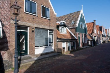 Kuzey Hollanda 'da turistler, Amsterdam yakınlarındaki eski otantik balıkçı köyü Volendam' da eski evler ve ilkbaharda dar sokaklar