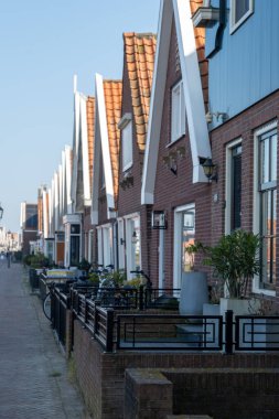 Kuzey Hollanda 'da turistler, Amsterdam yakınlarındaki eski otantik balıkçı köyü Volendam' da eski evler ve ilkbaharda dar sokaklar