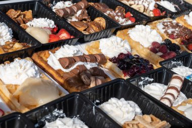 Farklı malzemelerle zenginleştirilmiş taze waffle çeşitleri, tatlı tatlılar, çikolata, krema, meyve ve meyveler, pastanede şekerleme dükkanı, eski Volendam, geleneksel Hollanda tatlıları