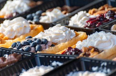 Farklı malzemelerle zenginleştirilmiş taze waffle çeşitleri, tatlı tatlılar, çikolata, krema, meyve ve meyveler, pastanede şekerleme dükkanı, eski Volendam, geleneksel Hollanda tatlıları