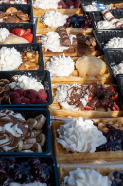 Farklı malzemelerle zenginleştirilmiş taze waffle çeşitleri, tatlı tatlılar, çikolata, krema, meyve ve meyveler, pastanede şekerleme dükkanı, eski Volendam, geleneksel Hollanda tatlıları