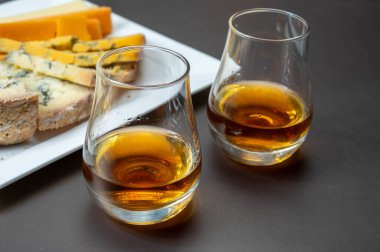 Viski ve peynir eşleşmesi, İskoç speyside viski bardakları ve dilimlenmiş çedar, mavi stilton ve mavi shropshire peyniri, İngiltere 'nin yiyecek ve içeceği.