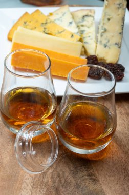 Viski ve peynir eşleşmesi, İskoç speyside viski bardakları ve dilimlenmiş çedar, mavi stilton ve mavi shropshire peyniri, İngiltere 'nin yiyecek ve içeceği.