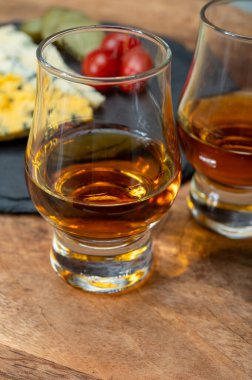 Viski ve peynir eşleşmesi, viski kadehleri ve dilimlenmiş eski mavi stilton ve mavi shropshire peynirleri, İngiltere 'nin yiyecek ve içeceği.
