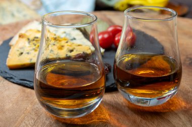 Viski ve peynir eşleşmesi, viski kadehleri ve dilimlenmiş eski mavi stilton ve mavi shropshire peynirleri, İngiltere 'nin yiyecek ve içeceği.