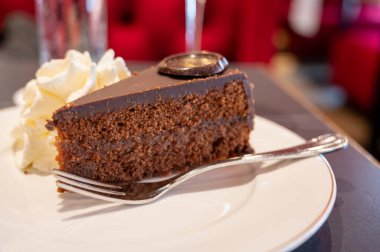 Avusturya kaynaklı kayısı reçelli ünlü Sachertorte çikolatalı keki Viyana 'daki eski klasik kafe restoranında kremayla servis ediliyor.