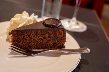 Avusturya kaynaklı kayısı reçelli ünlü Sachertorte çikolatalı keki Viyana 'daki eski klasik kafe restoranında kremayla servis ediliyor.