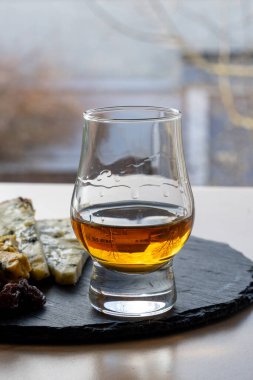 Viski ve peynir eşleştirme, viski bardağı ve tabağı tatma, dilimlenmiş eski mavi stilton ve mavi shropshire peyniri, İngiltere 'nin yiyecek ve içeceği.