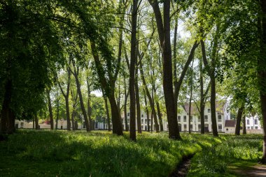 Bruges, Flanders 'da dantel ören rahibeler için ortaçağ manastırı, küçük beyaz evler ve Belçika' nın manastır duvarları içinde bir park.