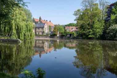 Bruges kasabası, Flanders, Belçika 'da güzel eski binaları olan göl ve şehir parkı manzarası.