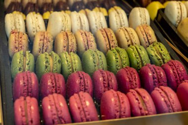 Makaronlar ya da Fransız kurabiyeli tatlı krema şekerli yumurta beyazı, krema şekeri, granüllü şeker, badem yemeği ve gıda boyası sergilenmekte olan tatlı Fransız tatlısı, kapat.