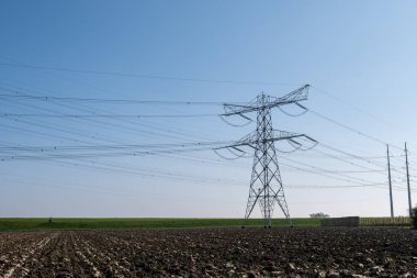 Yüksek voltaj hatları ve elektrik kuleleri Zeeland 'deki nükleer enerji santralinden güç transferi Hollanda' daki elektrik üretimi