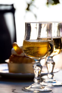 Fransız mutfağı, fırında pişmiş baba romlu kek, kremalı tatlı tatlı, rom ve taze ahududu, ve bir kadeh şampanya şarabı, yakın plan.