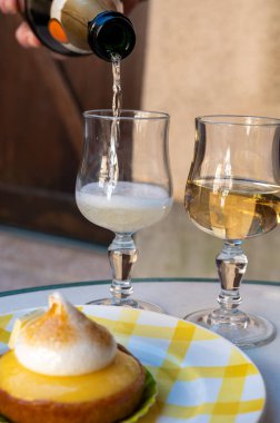 Bir Fransız limonlu turta ya da beyaz yumurtalı turta ve şampanyalı bardak köpüklü şarap, lezzetli tatlı, Fransız mutfağı.