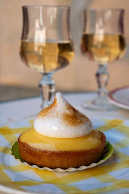 Bir Fransız limonlu turta ya da beyaz yumurtalı turta ve şampanyalı bardak köpüklü şarap, lezzetli tatlı, Fransız mutfağı.