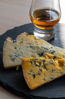 Viski ve peynir eşleştirme, viski bardağı ve tabağı tatma, dilimlenmiş eski mavi stilton ve mavi shropshire peyniri, İngiltere 'nin yiyecek ve içeceği.
