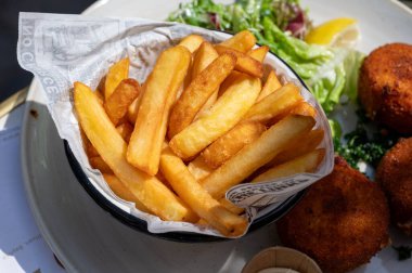 Açık kafede öğle yemeği. Vejetaryen peyniri ve yeşil kuşkonmaz kroket yanında taze salata ve Belçika, Bruges 'de patates kızartması.