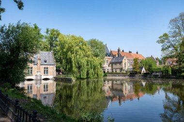 Bruges kasabası, Flanders, Belçika 'da güzel eski binaları olan göl ve şehir parkı manzarası.